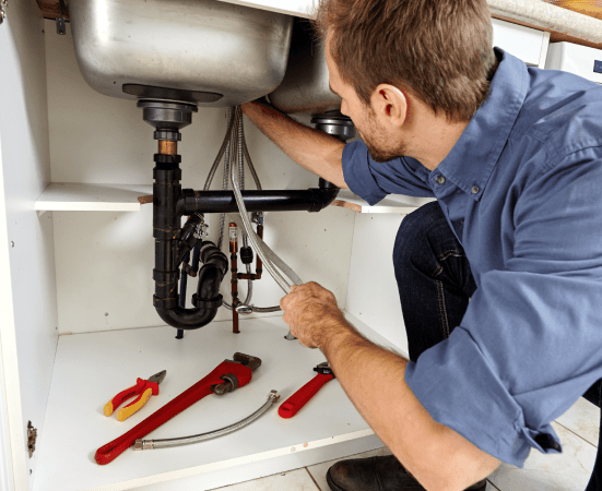 plumber fixing clogged drain pipe