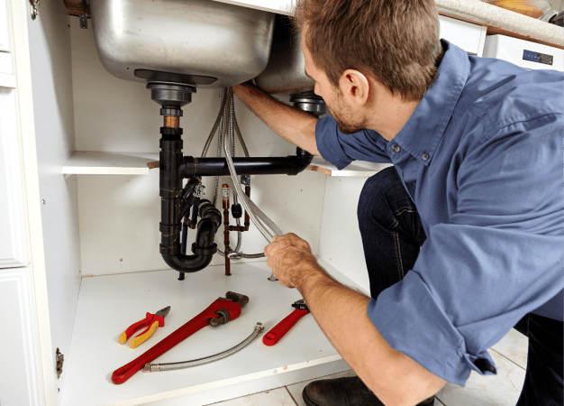 plumber fixing clogged drain pipe