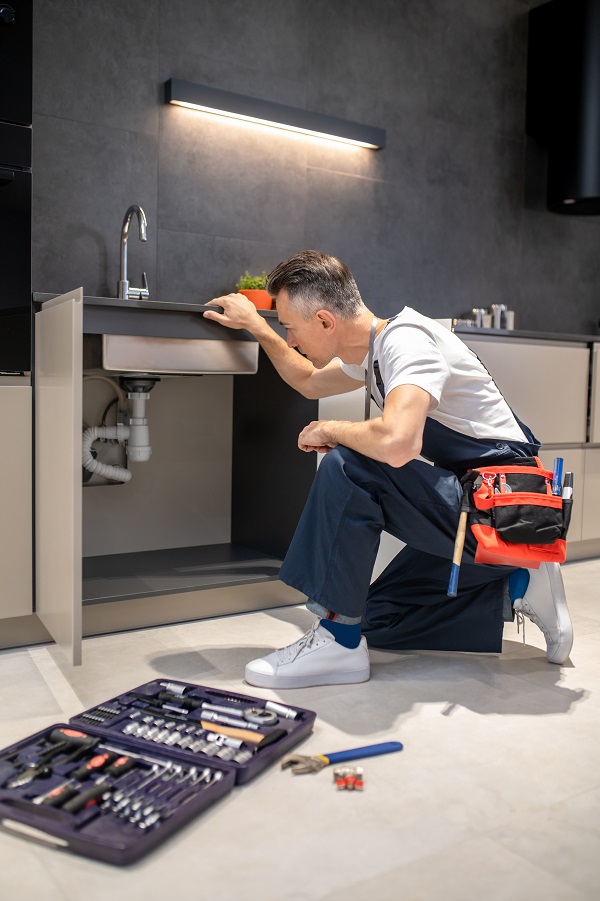 man fixing kitchen sink